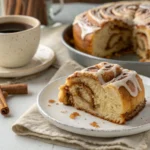 "Close-up of a freshly baked cinnamon roll cake with vanilla glaze."